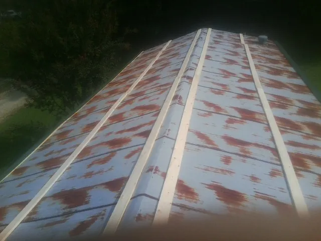 Rusted metal roof panels with new wood purlins before replacement — Storm Damage Roof Repair in Saint David by Roofing Brothers